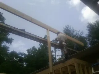 Carpenter setting a ridge beam over a new addition frame — Ice Dam Removal by Roofing Brothers in Dennis Port