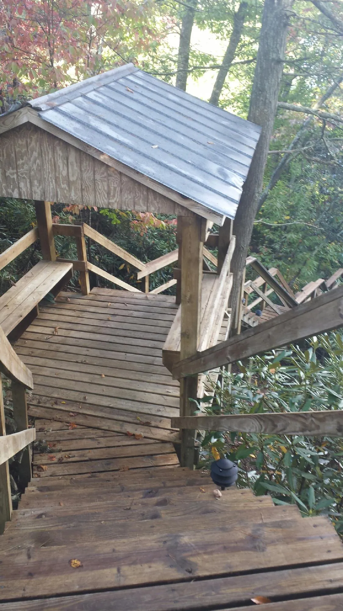 Metal roofed shelter over wooden steps on a wooded walkway — Skylight Repair & Installation work by our crew in Dennis Port