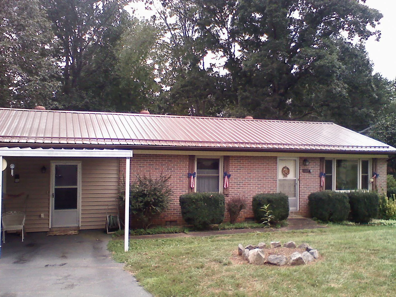 Bronze metal roof and carport on a brick ranch home — Roof Repair work by our crew in Dennis Port